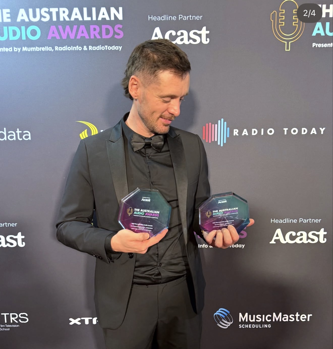 Josh Fox holding two Australian Audio Awards