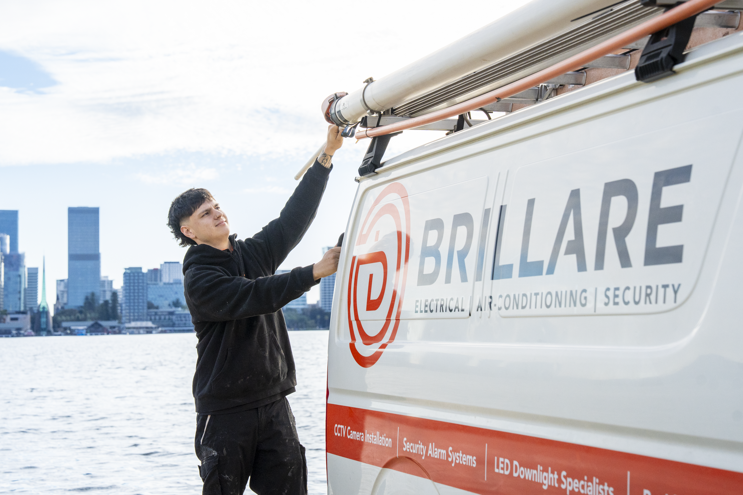 Brillare electrician working beside a branded service vehicle on the Perth waterfront
