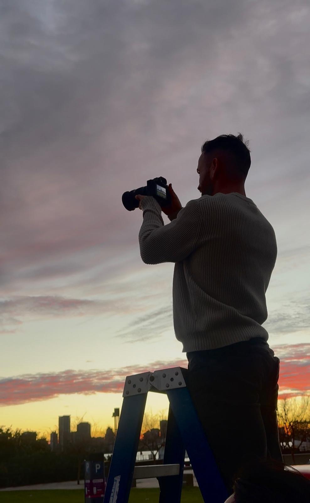 AIIMS camera operator filming a dramatic sunset scene in Perth