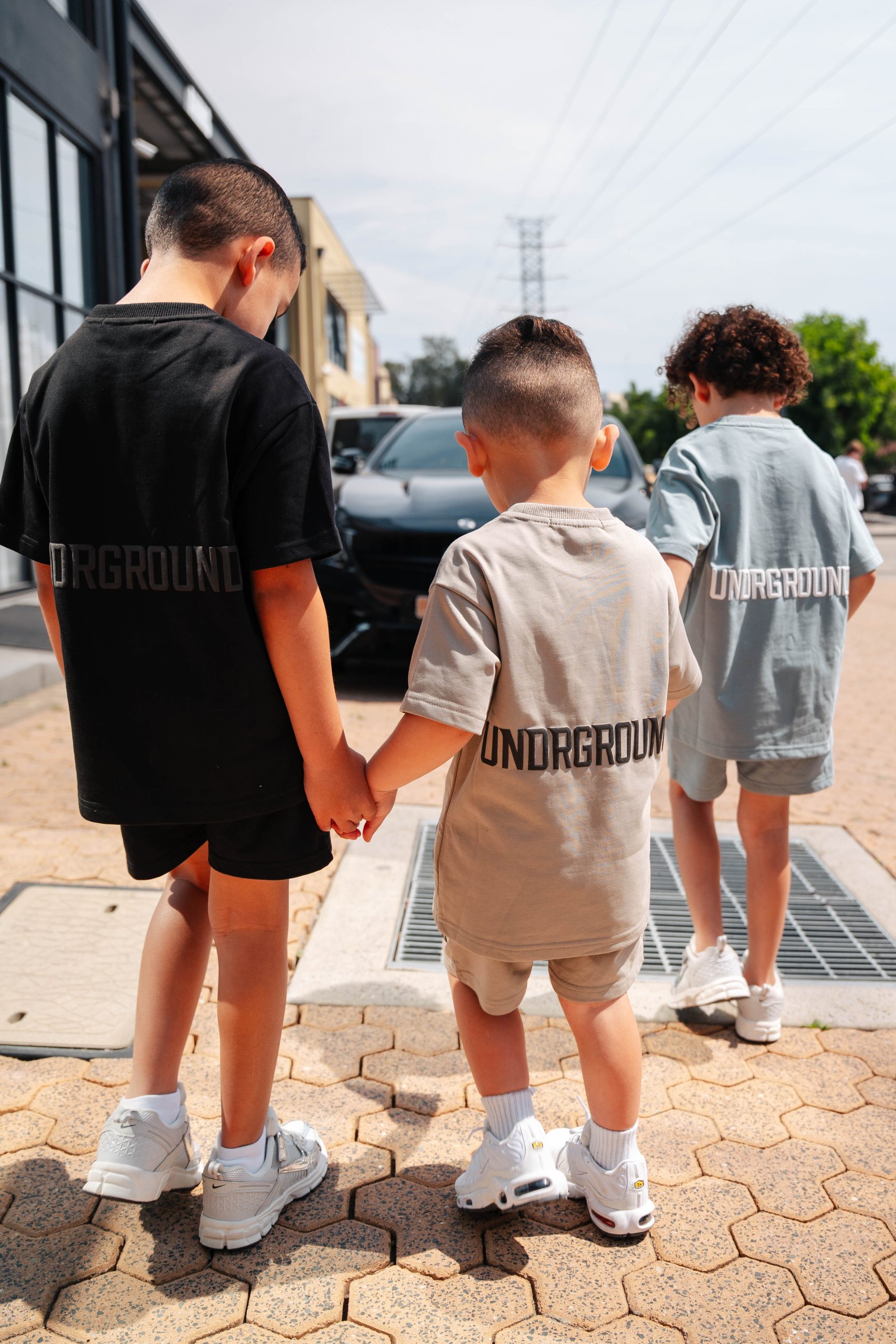 Children wearing coordinated UNDRGROUND streetwear from behind