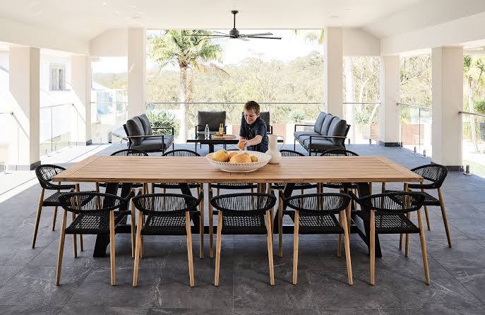 Woodbury Furniture outdoor dining table and woven chairs in a covered patio